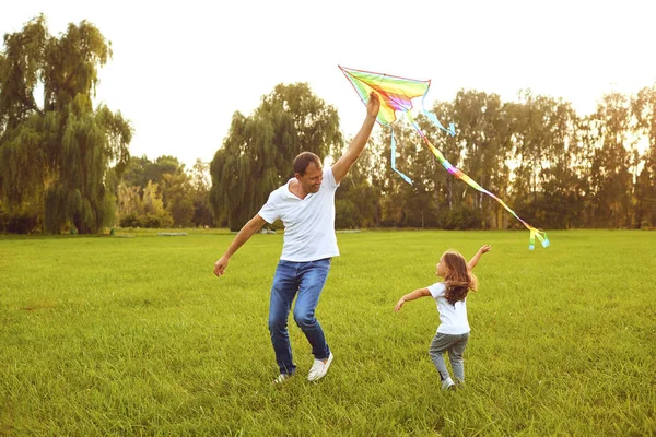 Glücklicher Familienvater und Kind laufen im Sommer mit dem Drachen auf der Wiese durch die Natur — Stockfoto