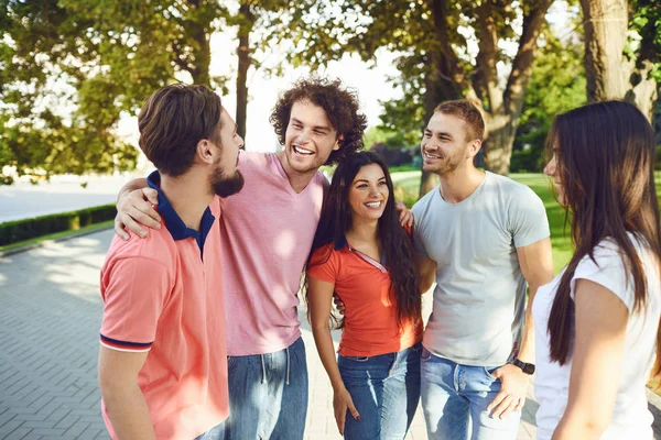 Genç arkadaşlar yazın sokakta konuşurken eğlenirler.