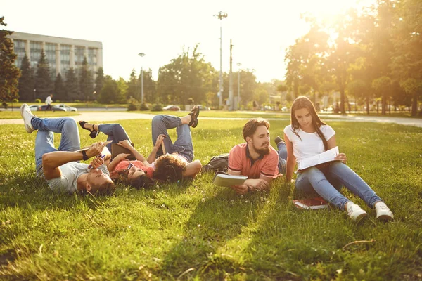 Молодые люди смеются, лежа на траве — стоковое фото