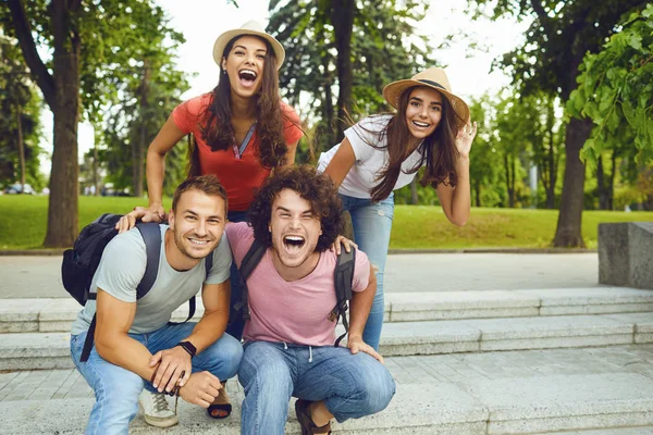 Amici felici seduti nella città del parco — Foto Stock