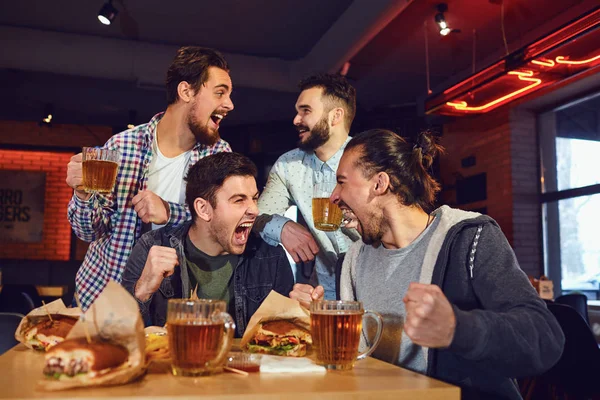 Gli amici fan guardano la tv sportiva al bar — Foto Stock