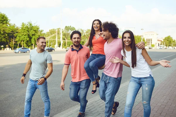 Gelukkige vrienden wandelen door de straten van een Europese stad. — Stockfoto