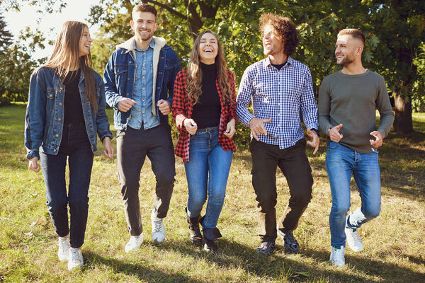 Casual happy friends strolling in park