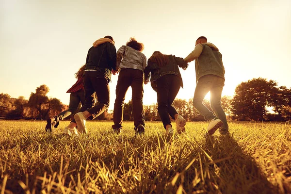 Köra vänner i Golden Sunny Field — Stockfoto