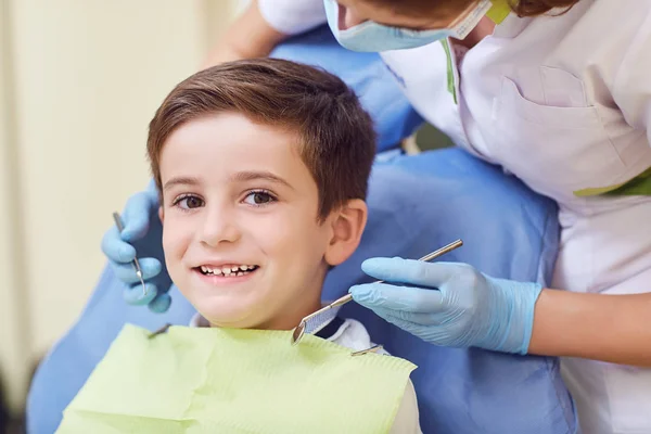 Uma criança com um dentista em um consultório odontológico . — Fotografia de Stock