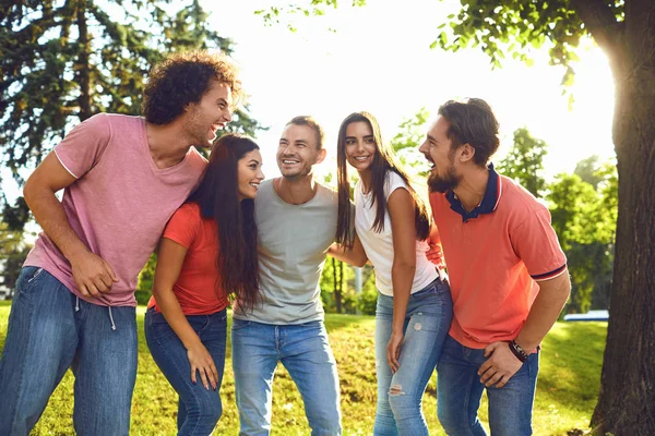 Grupa przyjaciół śmieje się w parku miejskim. — Zdjęcie stockowe