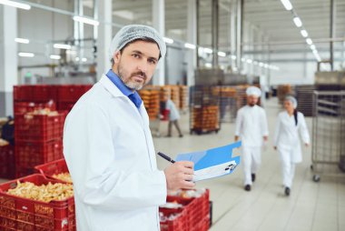 Technologist müfettiş fabrikada kağıtları ile klasöre bir giriş yapar