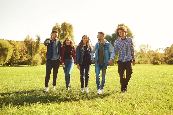 Jóvenes caminan en el parque en primavera . — Foto de Stock