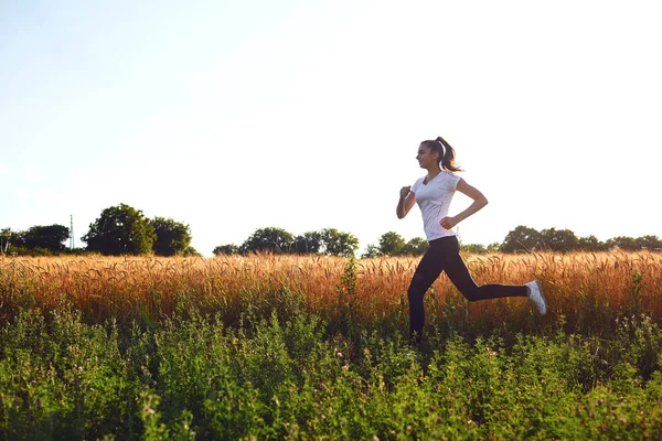 Ragazza corridore corre lungo la strada in estate . — Foto Stock