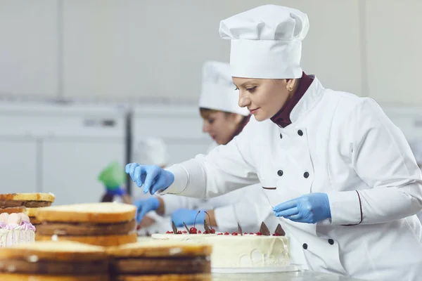 Pasticciere con torta pasticcera in mano al panificio . — Foto Stock