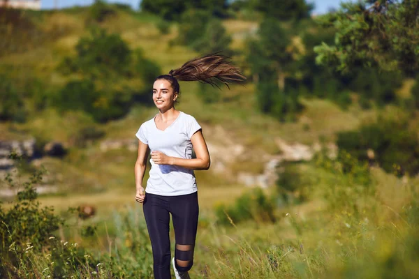 Девушка-бегунья бегает по природе летом . — стоковое фото