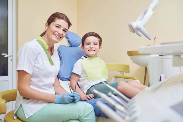Дорослий стоматолог з маленьким пацієнтом в лікарняному кабінеті — стокове фото