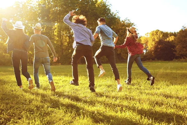 Een groep jonge mensen die door het Park rennen. — Stockfoto