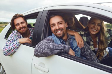 Bir grup mutlu arkadaş arabada araba kullanıyor..