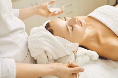 Bir kozmetoloji kliniğinde maske yapan genç güzel kadın.