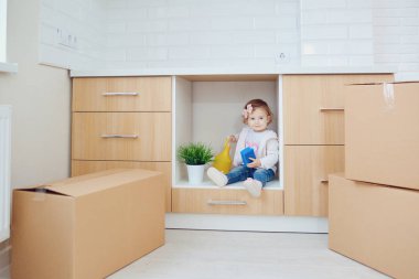 Çocuk yeni evdeki kutuları boşaltıyor.