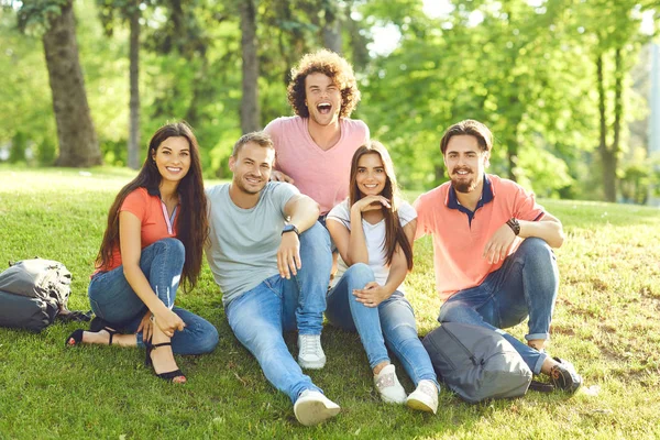 Vrienden plezier zittend op het gras in een stadspark — Stockfoto