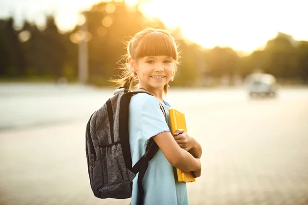 Bonne petite étudiante avec un sac à dos sur le chemin de l'école. — Photo