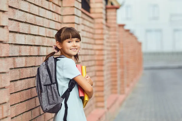 Écolière avec un sac à dos à la main va à l'école. — Photo
