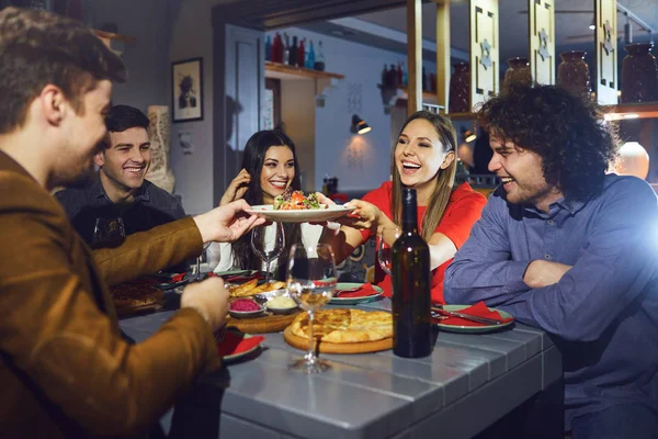 Přátelé jedí na večeři na schůzce v restauraci. — Stock fotografie