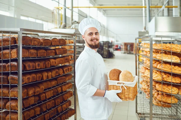 Il fornaio barbuto sorride con in mano un cesto di pane alla pasticceria — Foto Stock