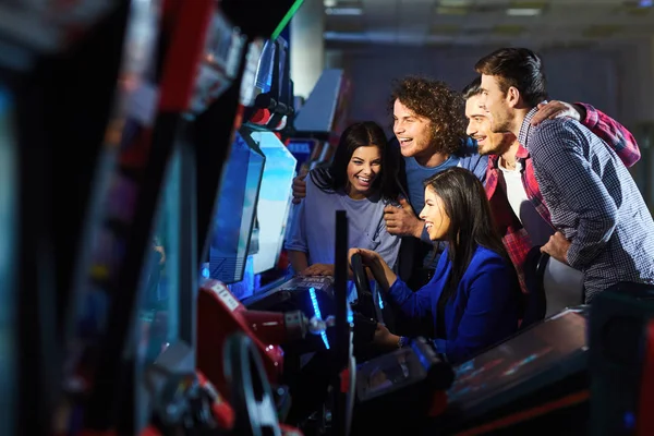 En grupp vänner som spelar arkadmaskin. — Stockfoto