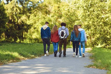 Parkta dolaşan bir grup modern insan