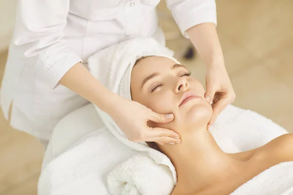 Beautician makes facial massage to the girl — Stock Photo, Image