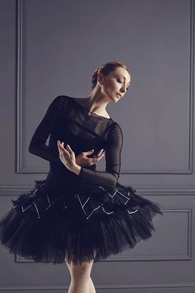 Μπαλαρίνα σε μια μαύρη φούστα που ποζάρει σε μαύρο φόντο. — Φωτογραφία Αρχείου