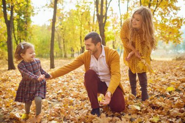 Aile sonbaharda parkta oynuyor..