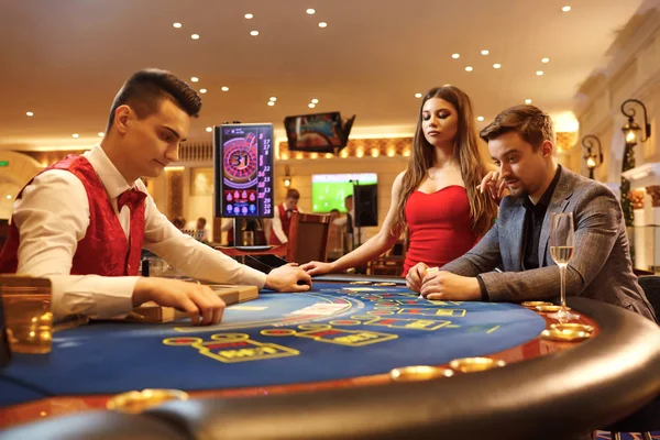 Young couple playing poker cards roulette in a casino. — Stock Photo, Image