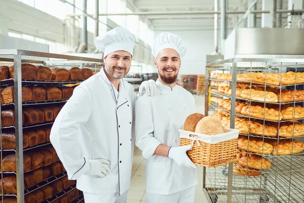 Panettieri sullo sfondo di vassoi con pane in una panetteria . — Foto Stock