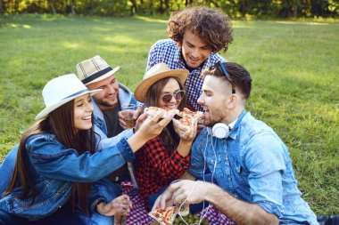 Bir grup genç insan parkta piknik sahip.