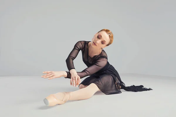 Ballerina in a black tutu elegantly dancing on a black background. — Stock Photo, Image