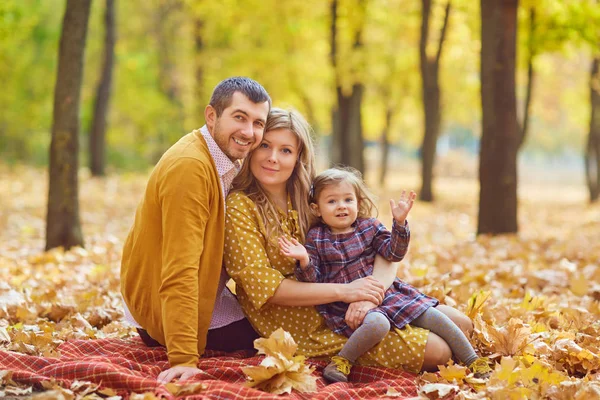 Sonbaharda parkta bir kızı olan mutlu bir aile. — Stok fotoğraf