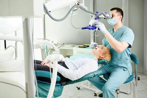 Male dentist looking through a microscope — Stock Photo, Image