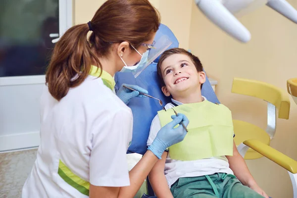 Een kind met een tandarts in een tandheelkundige kantoor. — Stockfoto