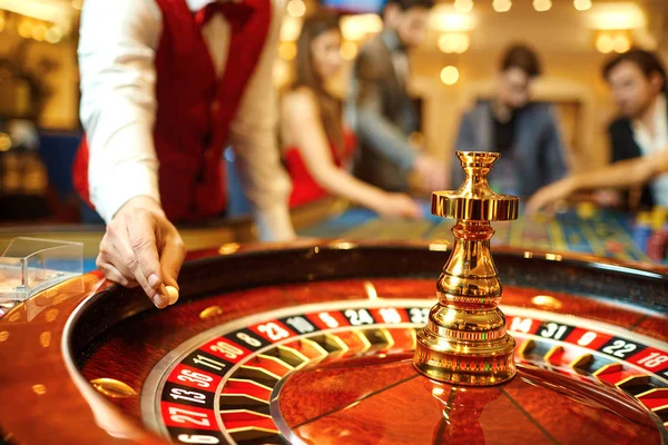Kroupier trzyma piłkę w ruletkę w kasynie w ręku. — Zdjęcie stockowe