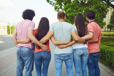 Yaz aylarında bir şehir caddesinde gülümseyen insanlar grubu.