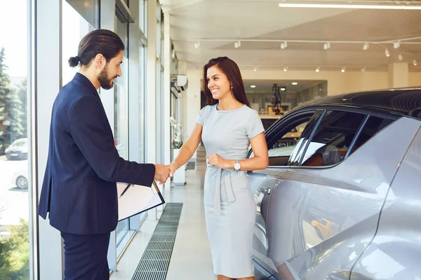 Comprador menina aperta as mãos carro revendedor — Fotografia de Stock