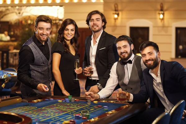 En grupp vänner på Casino Roulette Table. — Stockfoto