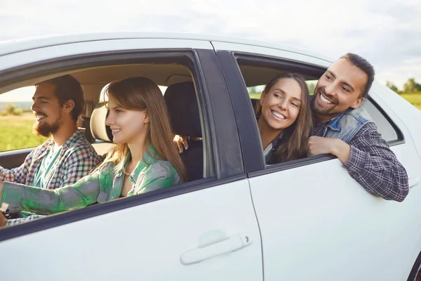 Een groep gelukkige vrienden rijden in een auto. — Stockfoto