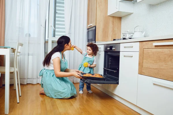 Mãe e filha cozinham doces no forno na cozinha — Fotografia de Stock