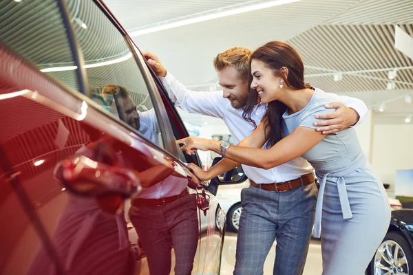 Mladý pár si zvolí nové auto v showroom. — Stock fotografie