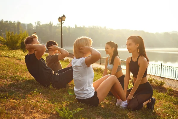 Група людей, які проводять вправи, сидять у парку — стокове фото