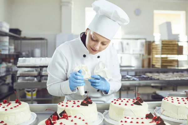 Pastelero con pastel en la mano en la panadería . — Foto de Stock