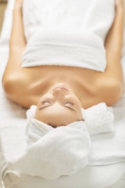 Genç bir kadın bir güzellik salonunda rahatlatıcı.