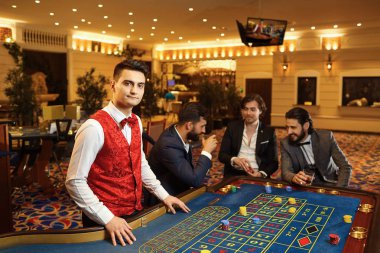 A croupier works at a poker roulette in a casino. clipart