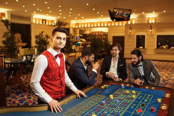 Ένας κρουπιέρης δουλεύει σε μια ρουλέτα πόκερ σε ένα καζίνο. — Φωτογραφία Αρχείου