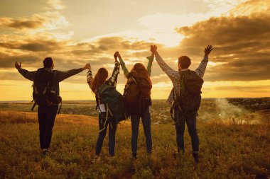 Kamp çadırı insanları turistler gün batımında doğada ayakta duruyorlar..